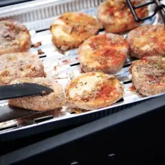 Oscypki w panierce smażone na grillu w aluminiowej tacce.